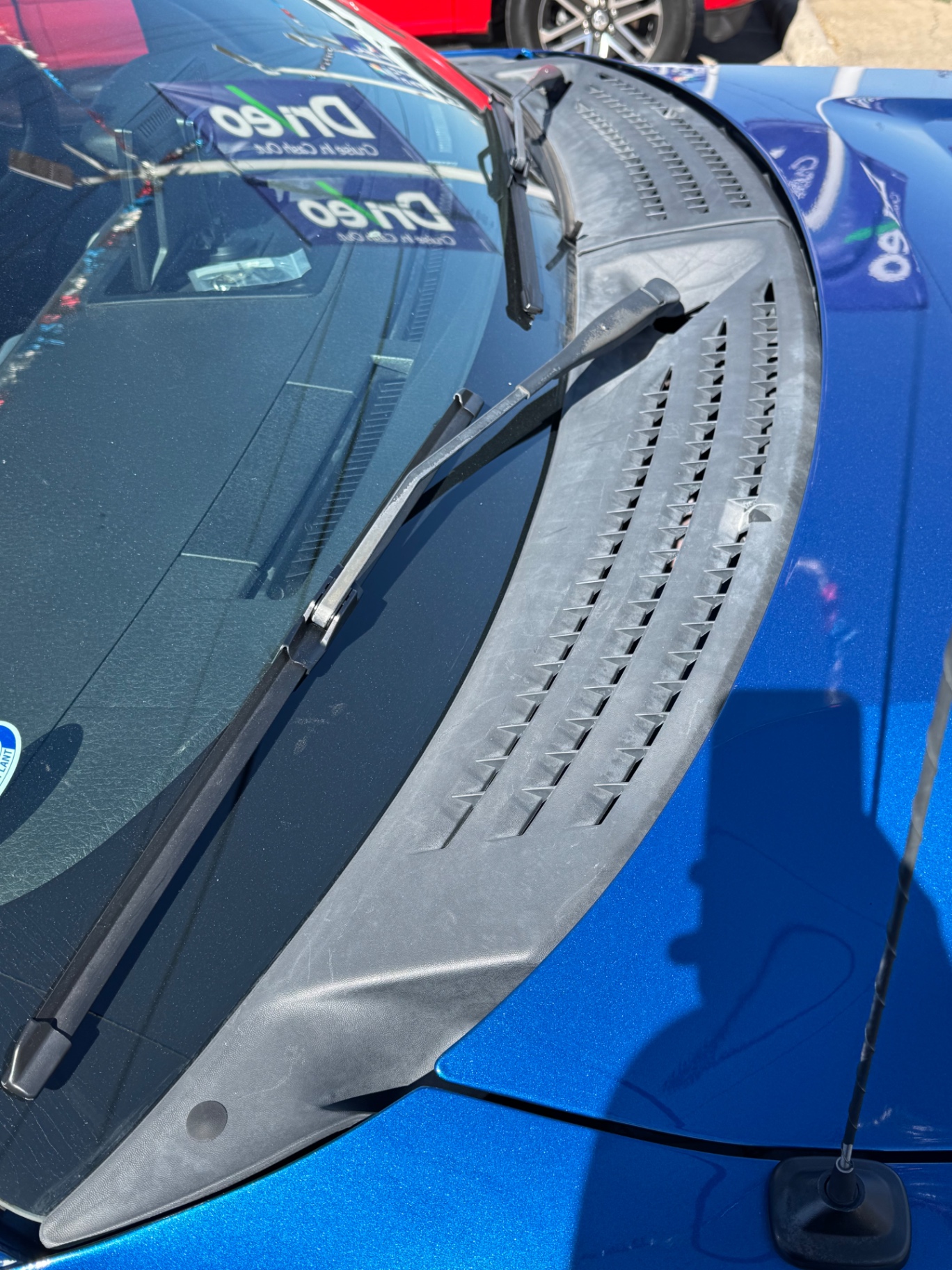 Before photo of sun-faded cowl panel and wiper arms on blue car